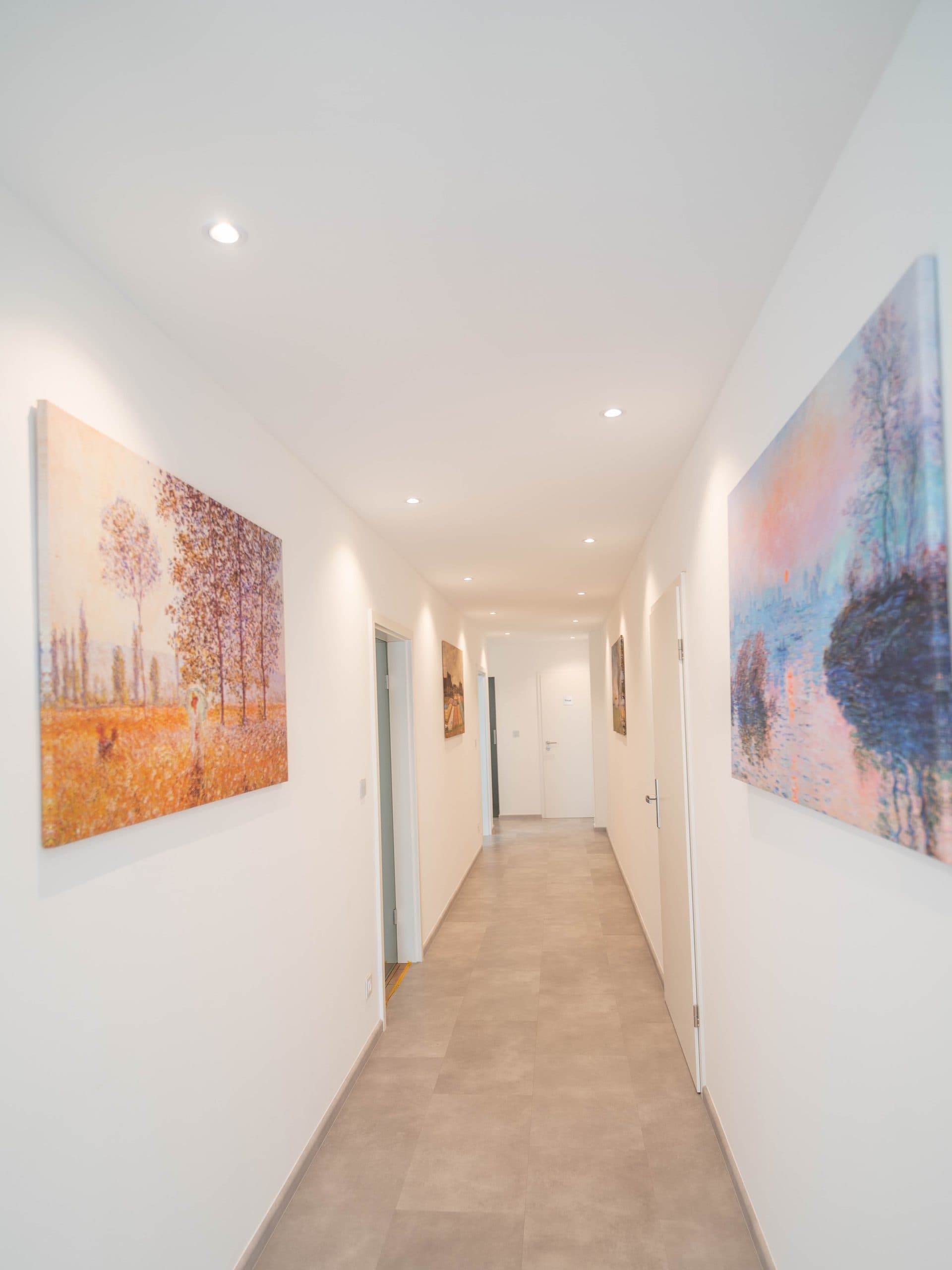 Le couloir du cabinet, éclairé, desservant les salles de soins