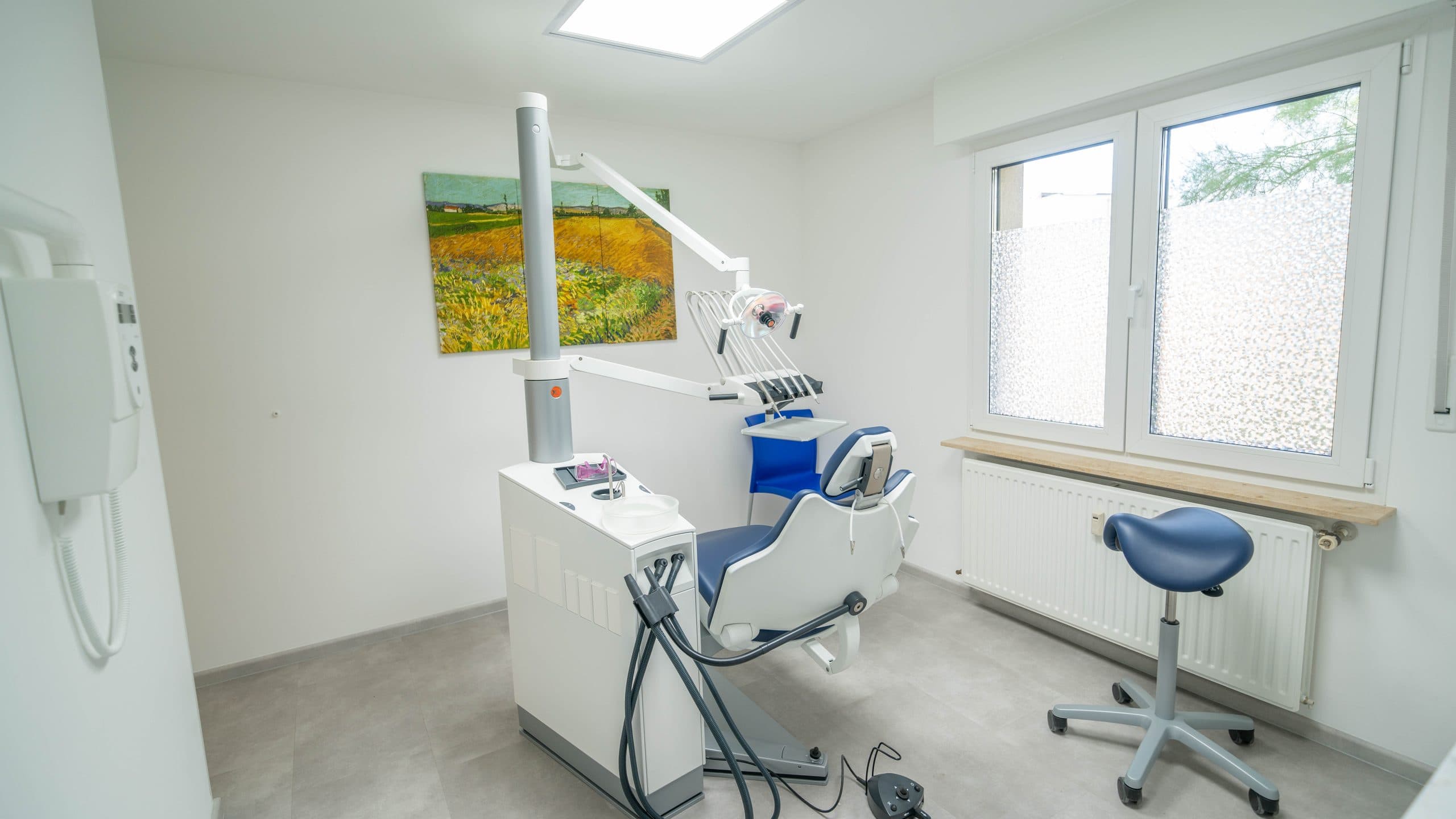 Une salle de soins du cabinet, vide et rangée, éclairée par la lumière du jour